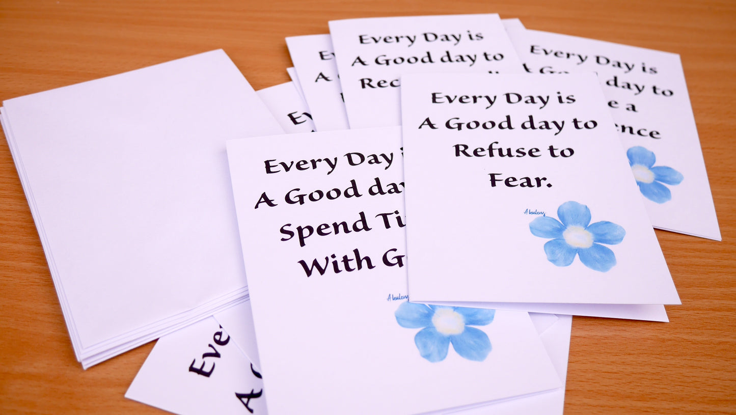 Motivational cards with inspirational messages and blue flowers on a wooden surface
