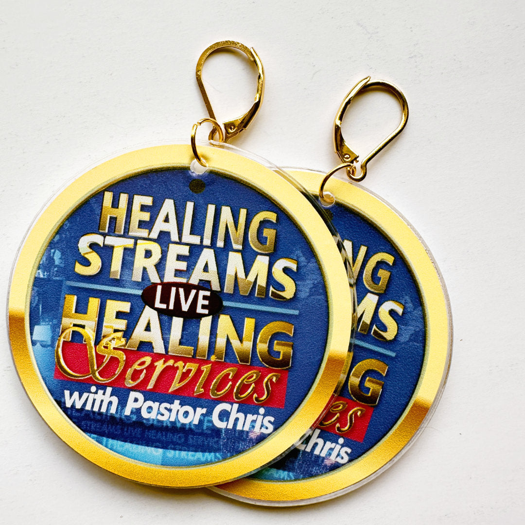 A pair of lever-clasp earrings with gold borders featuring text about Healing Streams and Pastor Chris on a white background.